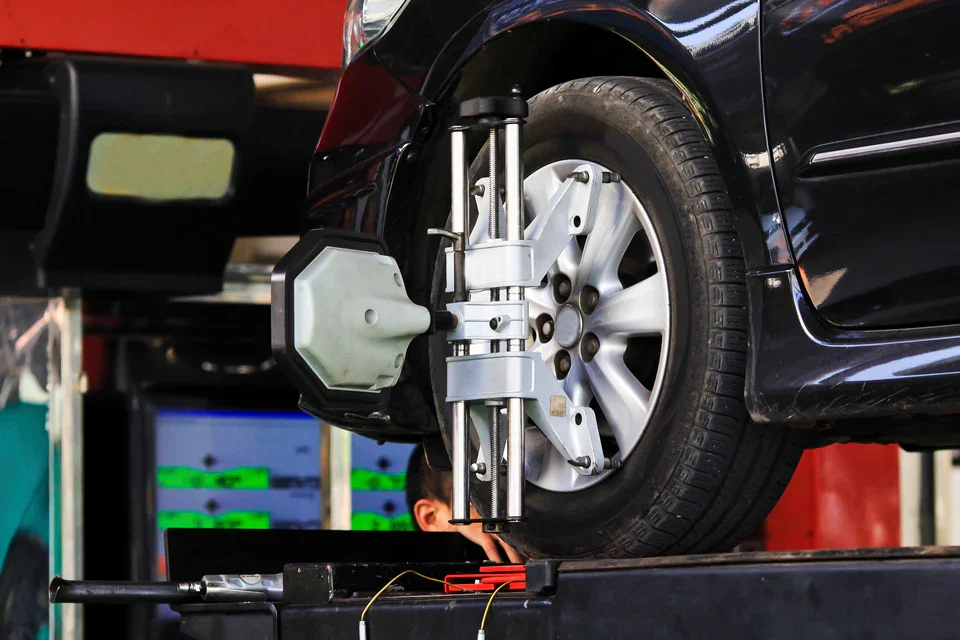 A car wheel undergoing a professional laser alignment check in a garage